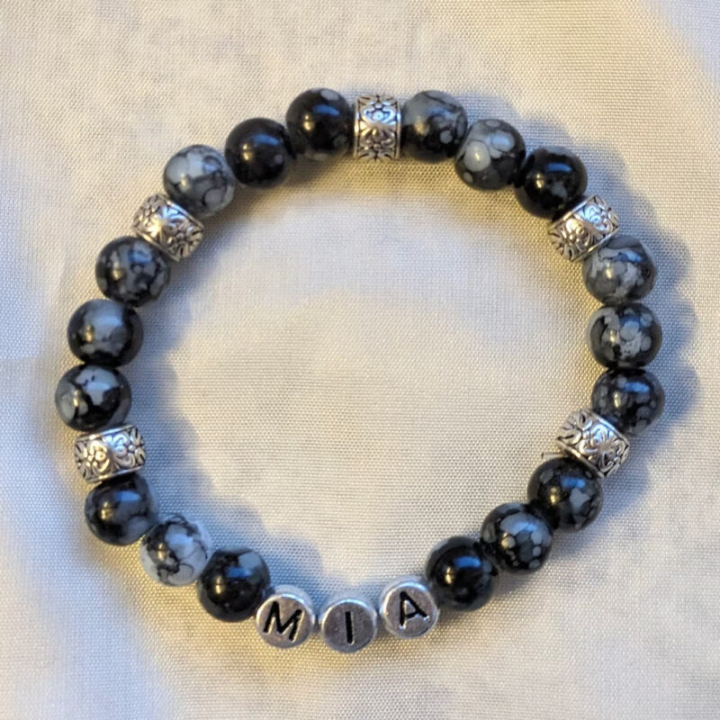 Namensarmband mit schwarz marmorierten Perlen. Die Zwischenringe sind silberfarben und mit antiken Mustern. Die Buchstaben sind schwarz auf silberfarbenen Perlen