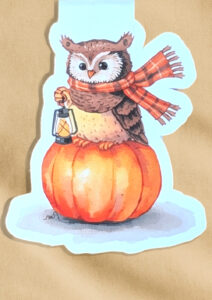 Magnetisches Lesezeichen mit Aquarell-Eule auf einem Kürbis.